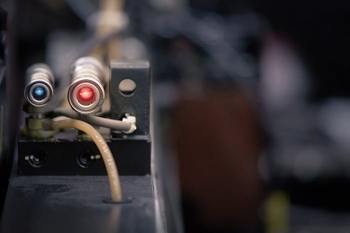 Photoelectric Sensor for distance detection in machine factory. Photo sensor installed in industrial machine.