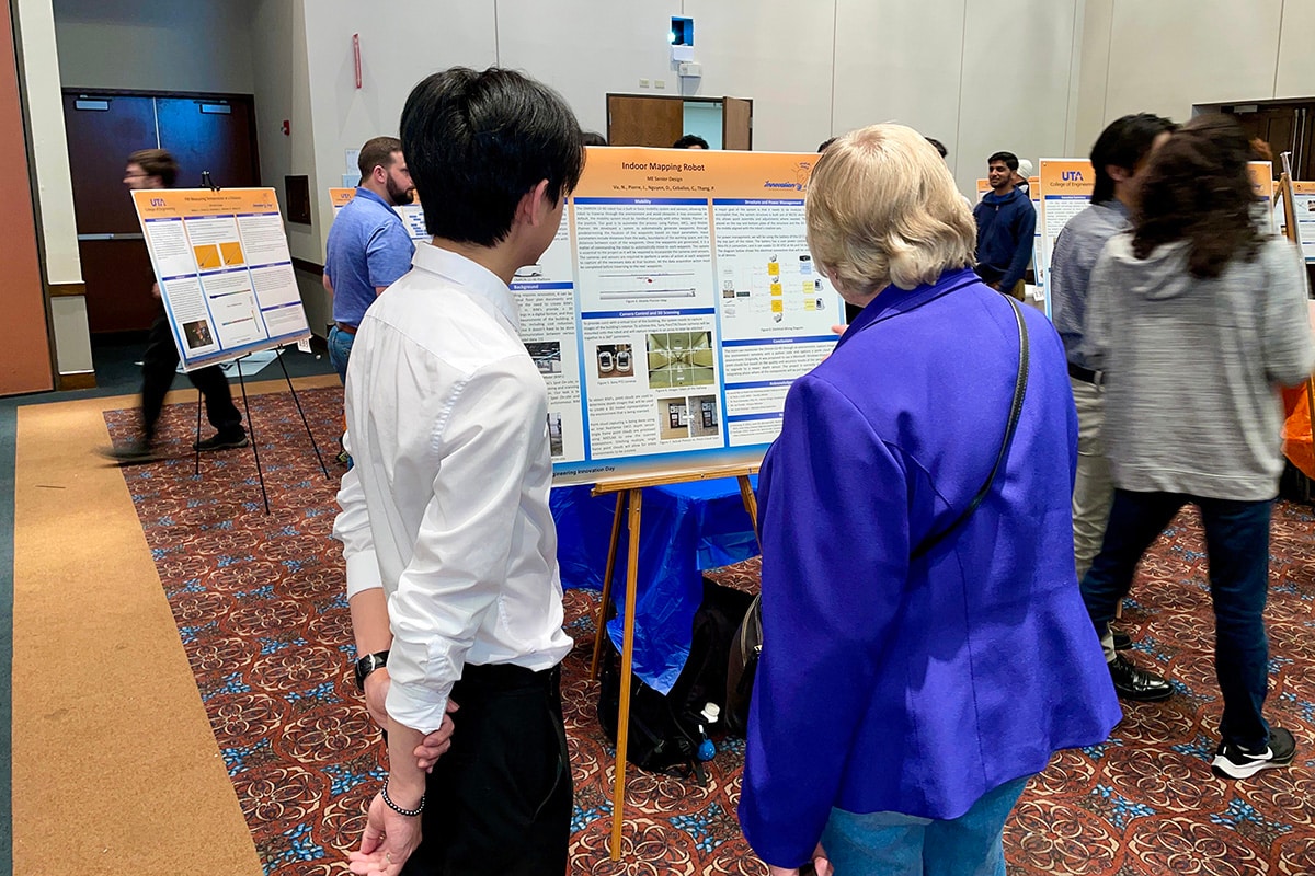 Student presenting his project to a woman at a UTA event - opens in a new tab